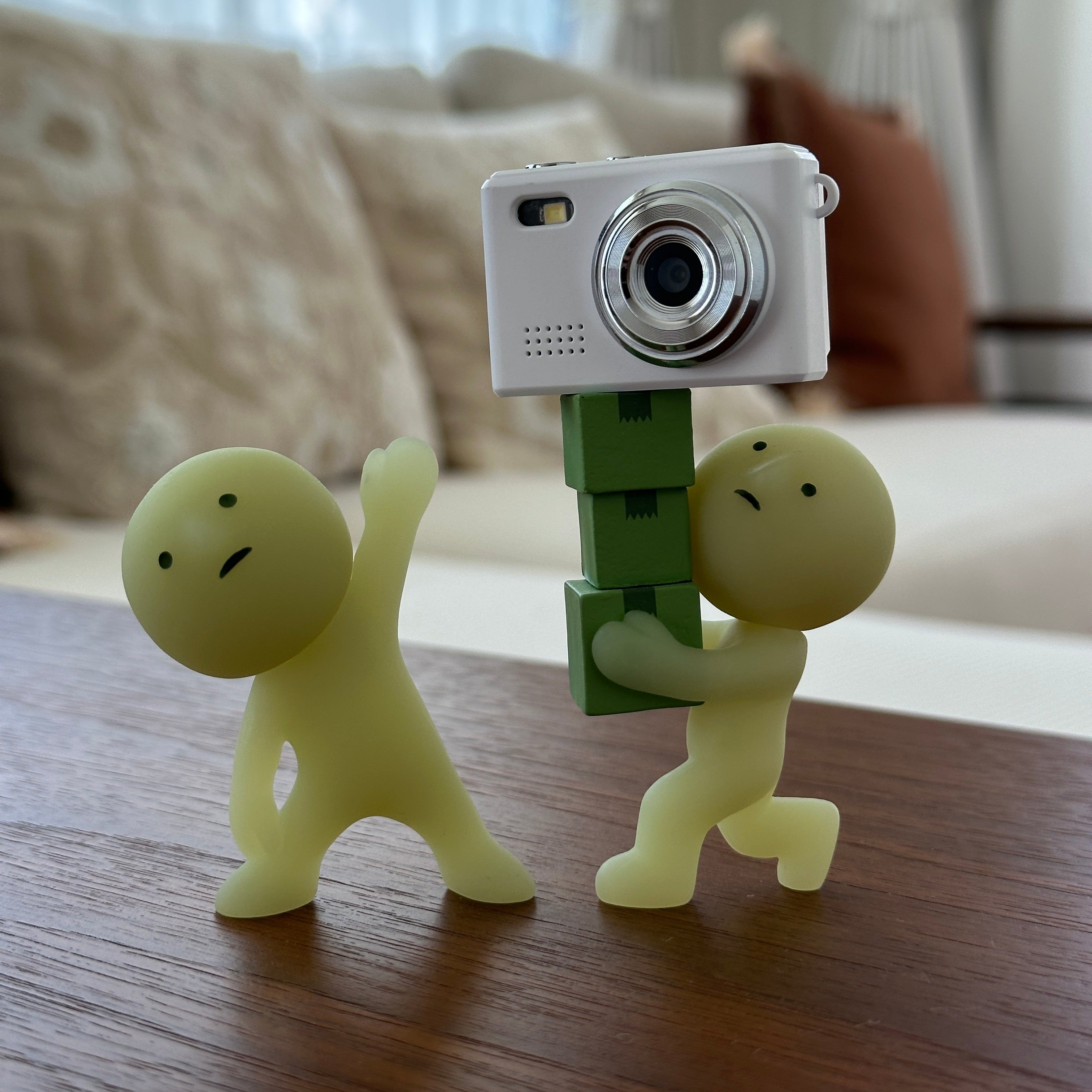 Serenovita Vitcam with a green clip holding three smiskis on a wooden surface.