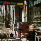 Outdoor seating area of a cafe with tables, chairs, and plants. Shot with SerenoVita VitaCam f(x) Film Camera