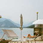 Beach scene with lounge chairs, umbrellas, and a mountain view. Shot with SerenoVita VitaCam f(x) Film Camera 
